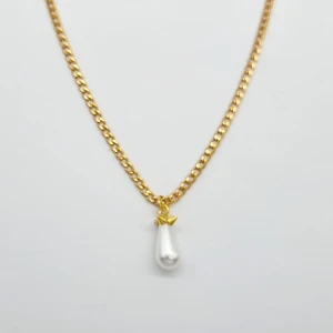 Guldhalsband med pärlhänge - Stilrent halsband i guldtonad kedja med ett droppformat vitt pärlhänge och en liten stjärndetalj i guld. Perfekt för dig som gillar klassiska smycken med en twist. Kedjan har en snygg länkdesign och pärlan ger en elegant vibe.