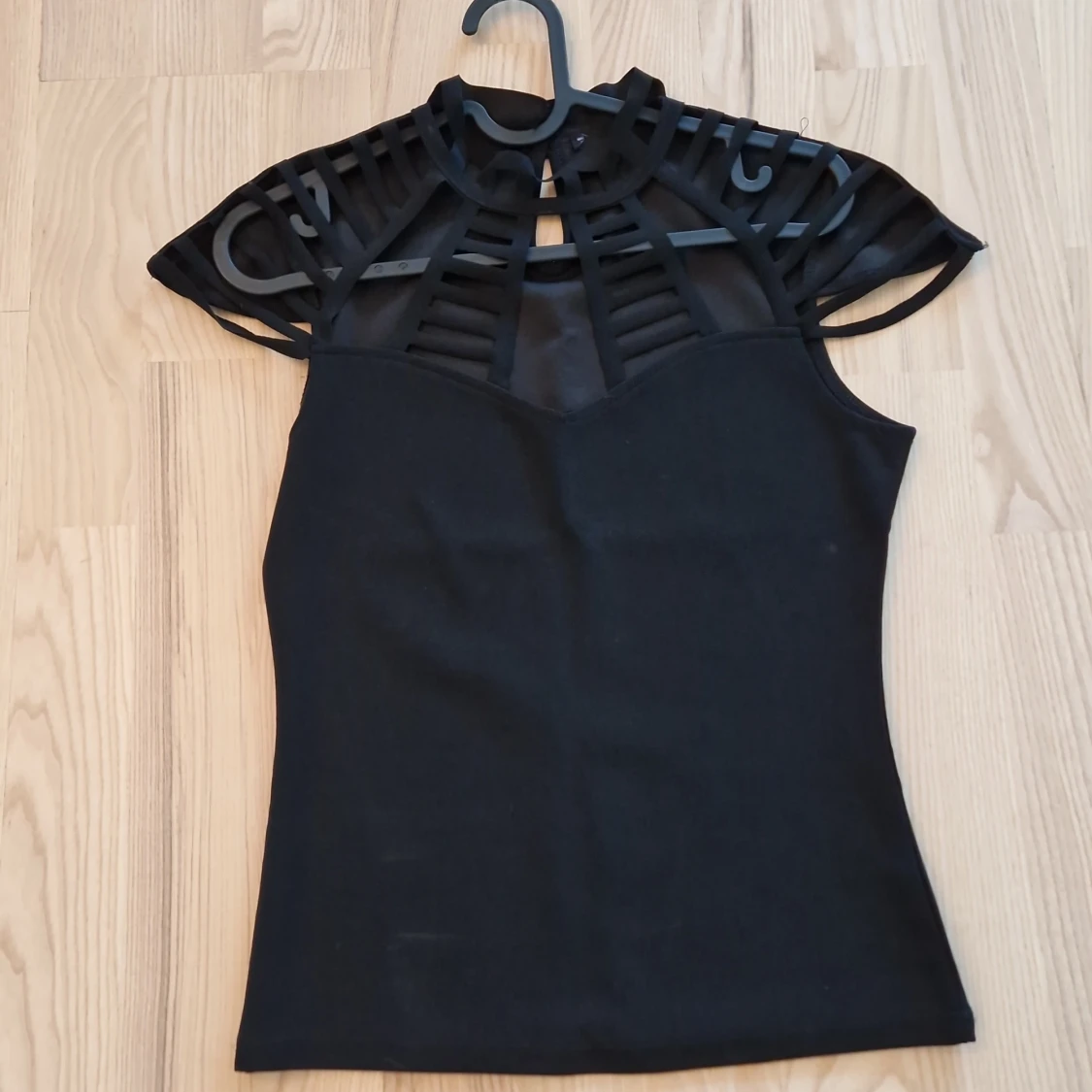 Svart topp med mesh och cut out-detaljer