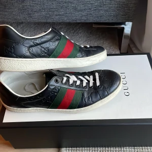 Gucci svarta sneakers med röd/grön rand - Gucci ace | storlek 38 men passar mig som har 37, passar även 39 | skick 9/10 har inga defekter är bara lite smutsiga under sulan | det kommer inte med kvitto och sånt, det kommer bara med 1 dustbag och en låda | jag kan skicka bild på kvittot om ni vill har äktehets bevis | nypris ca 8500kr mitt pris 1700kr | pris ej hugget i sten 🪨 |