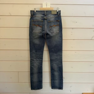 Nudie Jeans Grim Tim - Nudie jeans (Grim Tim) | Storlek: W31 L34 | Skick: 8,5/10, nudie loggan bak är uppskrapad. Se bild. Även två små fläckar på högra knät. | Hör gärna av er vid frågor och funderingar! Pris går att diskutera vid smidig affär🤗