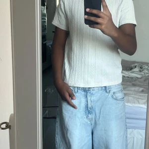 Vit pikétröja med struktur från SHEIN - Säljer en vit pikétröja från SHEIN med snyggt strukturerat mönster. Tröjan har korta ärmar och klassisk krage, perfekt för en chill och clean look. Materialet känns mjukt och har en stickad känsla. Passar dig som gillar enkel stil med lite extra detalj.