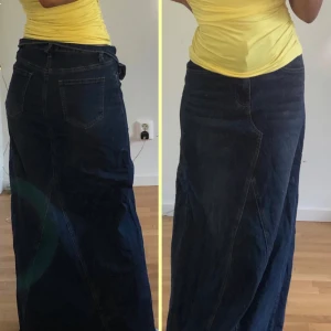 Mörkblå lång jeanskjol - Säljer en snygg mörkblå lång jeanskjol med klassiska fickor bak och fram. Kjolen har en rak passform och är gjord i robust denim som ger en cool och avslappnad vibe. Perfekt för dig som gillar tidlös stil och vill ha något som funkar året runt.