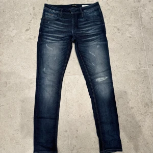 Mörkblåa Moratojeans med trendiga slitningar. - Säljer ett par snygga Morato-jeans i storlek 34, blåa med stilfulla slitningar. Skick 9,5/10 – nästan som nya med minimalt slitage. Hör gärna av dig om du har några frågor! Sitter mycket mindre 