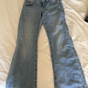 Bootcut jeans från Gina Tricot ljusblå - Snygga ljusblå bootcut jeans från Gina Tricot i storlek 152. Klassisk femficksmodell med dragkedja och knapp framtill. Jeansen har en bredare benvidd nedtill och är tillverkade i mjukt denimtyg som ger en chill vibe.