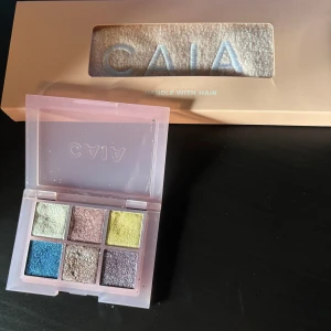 Caia  - Säljer mitt oöppnad caia hårband och en glittrig ögonskuggspallet. Ögonskuggspalletten är lite använd men är ändå i bar skick ! Säljer båda för 100kr+frakt