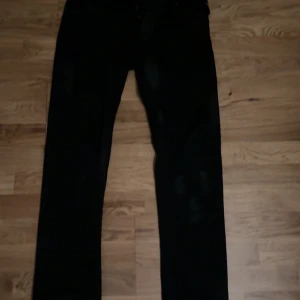  Replay jeans  - Säljer ett par svarta jeans från Replay med klassisk rak passform. Jeansen har knäppning med knappar, fem fickor och diskret Replay-logga på fickan. Snygga och stilrena, perfekta till sneakers eller boots. Helt nya använda en gång. Nypris 2100kr