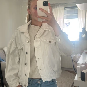 Vit jeansjacka  - Snygg vit jeansjacka från Gina Tricot i storlek S. Klassisk modell med silvriga knappar, två bröstfickor och elastisk nederkant. Jackan har lång ärm och är perfekt för dig som vill ha en clean och fräsch look. 