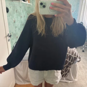 Mörkblå stickad tröja med håldetaljer - Säljer en mörkblå stickad tröja med rund hals och långa ärmar. Tröjan har snygga håldetaljer längs axlarna och en loose passform som gör den chill och enkel att styla. Perfekt för dig som gillar basic med en twist.