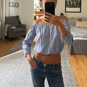 Ljusblå offshoulder topp Brandy Melville - Superfin ljusblå offshoulder topp från Brandy Melville. Croppad modell med trekvartsärmar och resår både upptill och nertill för en snygg passform. Perfekt till jeans eller kjol. 