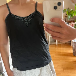 Söt topp - Gulligt linne med blommor, svartgrå färg. Passar en s-m. Fint skick! Pris 35kr. 