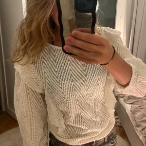 Vit spetsblus med volang från MNG - Supersöt vit spetsblus från Mango med zigzag-mönster och volangdetaljer på axlarna. Blusen har långärmade puffärmar. Perfekt för en snygg look! Den är i M men  passar mer s/xs så den är alltså lite mindre i storleken.💓som ni ser på bilden så är lappen med storlek o märket på av på ena sidan men det är inget som spelar roll då man bara kan klippa bort den!