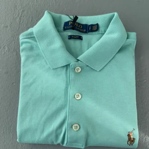 Mintgrön pikétröja från Ralph Lauren - Snygg Mintgrön raulph lauren piké med den ikoniska (bästa raffe logga designen som finns). Helt ny med inga defekter, köpt från CareofCarl för 1799kr. Perfekt nu vid de sista varma sommardagarna. Du får även me mina 110 exklusiva leverantörer på köpet.