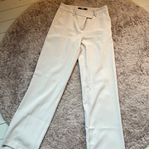 Beige kostymbyxor - Säljer dessa as nygga beige kostymbyxor från Bik Bok med raka ben. Inga större defekter och perfekt i höst! 