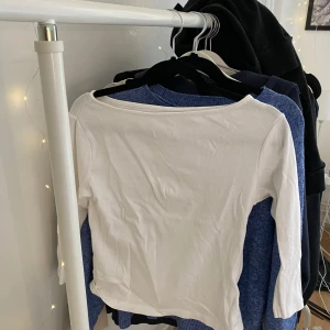 Vit långärmad topp med båtringning - En stilren vit långärmad topp med båtringning. Enkel och clean design som passar till det mesta. Tillverkad i mjuk bomull som känns skön mot huden. Perfekt att matcha med jeans eller kjol för en avslappnad look.