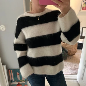 Randig mohair tröja - Supermysig och fluffig tröja med breda svarta och vita ränder. Tröjan har rund hals och långa ärmar, och är gjord i det mjuka stickade materialet mohair🥰Oversized. 