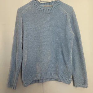 Ljusblå stickad tröja från 157 - Supermysig ljusblå stickad tröja från 157 med rund halsringning och ribbade muddar vid ärmslut och nederkant. Perfekt för skolstarten och chill dagar. Enkel och stilren design som passar till det mesta. 