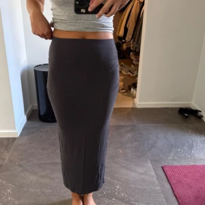 Mörkgrå långkjol Gina Tricot - Säljer en mörkgrå långkjol med tight passform från Gina tricot 