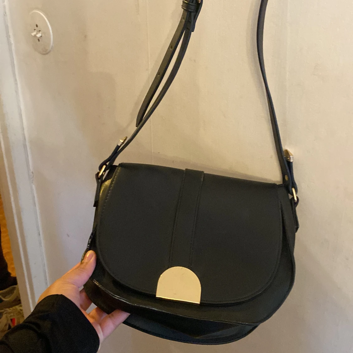 Svart axelväska med gulddetalj