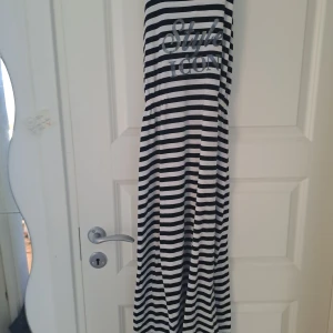 Randig klänning från Primark - Säljer en cool randig klänning från Primark med texten 'Style Icon' på bröstet. Klänningen har svarta och vita ränder och är ärmlös, perfekt för en avslappnad stil. Tillverkad i ett mjukt och bekvämt material.