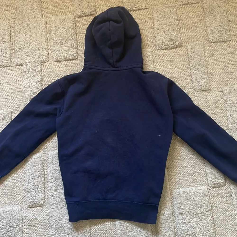 Säljer en snygg marinblå hoodie från Polo Ralph Lauren med dragkedja och huva. Den har en gul broderad logga på bröstet och vita snören vid huvan. Perfekt för en avslappnad stil. Pris kan diskuteras!. Neuletakit & Villapaidat.