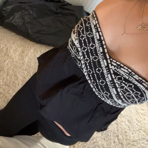 zara tubtopp - Snygg svart och vit tubtopp med geometriskt mönster. Perfekt för en stilren look. Toppen är axelbandslös och har en bekväm passform.