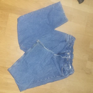 Blå jeans från H&M - Säljer ett par blå jeansbyxor från H&M med loose fit och justerbar midja. Byxorna har en klassisk design och går ihop med de flesta färgerna. Storleken står i 164 men funkar även prima för S. Byxorna är använda cirka 3-5 gånger och har ingen defekt. Priset är diskuterbart, så kontakta gärna!