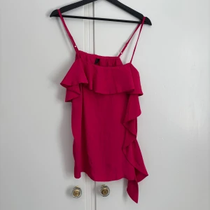Topp från Vero Moda - En snygg rosa/röd topp från Vero Moda med volangdetaljer. Perfekt för sommaren. Storlek M och i bra skick💗