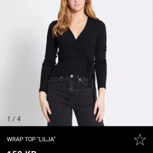 Svart omlottopp 'Lilja' - Snygg svart omlottopp med långa ärmar och knytning i sidan. Säljer då den inte kommer till användning. Köpte för 150kr. Aldrig använd💞🫶🏻