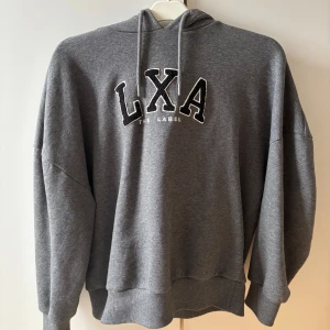 Grå hoodie från LXA The Label - Säljer för använder den inte, men den har varit använd fåtal gånger. Köpt på nypris💕
