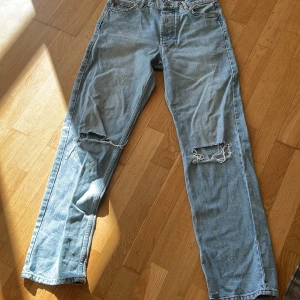Ljusblå jeans från Junkyard - Säljer ett par ljusblå jeans från Junkyard med slitna detaljer på knäna. De har en klassisk femficksdesign och en bekväm passform. Perfekta för en avslappnad stil. De är bara använda 3-4 gånger max då de inte passade mig.