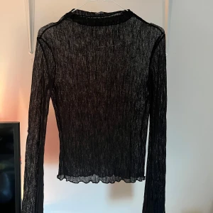 Svart transparent topp från Gina Tricot - Svart mesh topp från Gina Tricot. Med lite polokrage. Använd enstaka gånger💕