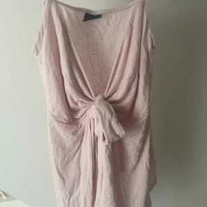 Ljusrosa topp med knyt - Säljer en söt ljusrosa topp med en knyt framtill. Toppen har smala axelband och fin passform. Från gina tricot i storlek s.💗