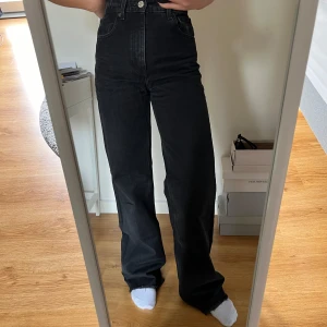 Svarta högmidjade jeans - Svarta vida högmidjade jeans. Jag har använt byxorna lite och eftersom de är avklippta i modellen från början, är de kortare än när jag köpte dem. Dock var de för långa först, men nu passar de bra längdmässigt för mig som är 170 cm 🤍