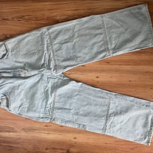 Ljusblå jeansbyxor från District FortySix - Säljer ett par ljusblå jeansbyxor från District FortySix. Byxorna har en loose passform med elastisk midja och stora fickor baktill. Perfekta för en avslappnad stil. (Pris kan diskuteras vid snabb affär/upphämtning)