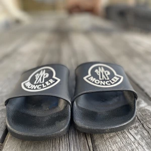 Svarta sandaler från Moncler - Snygga svarta sandaler från Moncler med logotyp på ovandelen. Perfekta för en avslappnad stil. Bra för komfort och hållbarhet.           Storlek 41 men mer 39