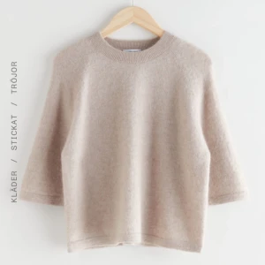 Other Stories stickad tröja - Säljer en mysig stickad topp i alpackablandning med trekvartsärm. Perfekt för kyliga dagar och enkel att matcha med olika outfits. Tröjan har en rund halsringning och en avslappnad passform.
