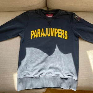 Mörkblå sweatshirt från Parajumpers - Säljer en mörkblå sweatshirt från Parajumpers med stor gul logga på bröstet och broderad patch på ärmen. Tröjan har rund hals, långa ärmar och är gjord i mjuk bomull.Storlek Ys (Young small).  [Skick 8/10] [nypris 1700+] . [Pris 400kr] Skriv vid behov av flera bilder eller övriga funderingar.
