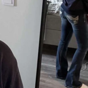Blå bootcut jeans från Gina Tricot - Snygga blå bootcut jeans från Gina Tricot med markerade vita sömmar och broderade bakfickor. Jeansen har klassisk femficksdesign och är tillverkade i mjukt denimtyg. Perfekta för dig som gillar en retroinspirerad look med lite extra detaljer.