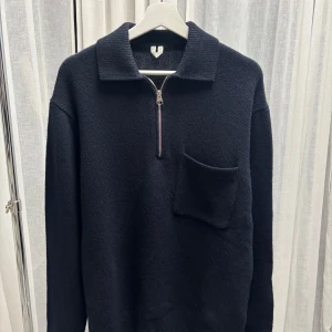 Stickad Arket tröja med half zip - Stickad tröja med krage och half zip-dragkedja framtill från Arket. Tröjan har en stor bröstficka och långa ärmar. 
