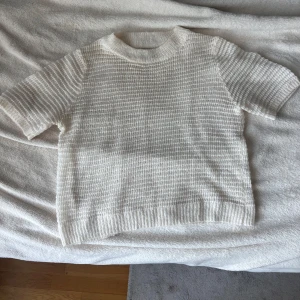 Vit stickad mohairtröja Mango - Supermjuk vit stickad kortärmad tröja från MNG i mohair. Tröjan har korta ärmar, ribbade muddar och rund hals. 