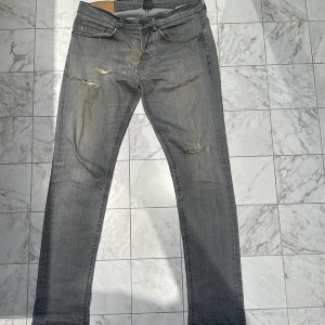 Dondup jeans  - Säljer ett par sköna Dondup jeans i storlek 32 samt färg grå. Finns två feta hål på baksidan av jeansen, men dom kan lämnas in och fixas för några hundra kronor. Modellen är George så jeansen är alltså slim. Kom dm för fler frågor osv.