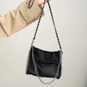 Svart Gina Tricot väska  - Svart väska från Gina tricot med silverfärgade kedjor längs kanterna och som axelrem. Använd väldigt få gånger och har inget slitage. Hör gärna av er vid frågor eller funderingar.