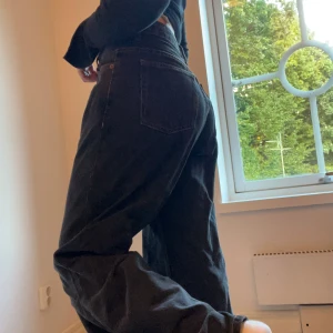 Svarta wide baggy jeans från Dr Denim - Säljer ett par svarta jeans från Dr Denim, modell Hill Dust Washed Black. De har en loose och wide passform med hög midja och klassiska fickor. Materialet är 100% bomull och jeansen har kontrastsömmar i brunt. Perfekt för dig som gillar baggy jeans. 