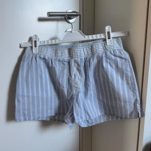 Blå- och vitrandiga shorts med knappar - Shorts, Inte använda prislapp kvar. 