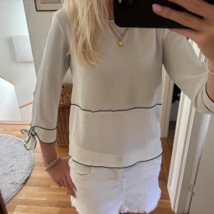 Vit blus med svarta kanter från Zara - Superfin vit blus från Zara med knyten vid ärmarna. Blusen är gammal från Zara som inte längre säljs, så söt inför hösten!❣️🍂
