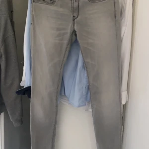 Replay grå jeans slim fit - Säljer ett par snygga grå jeans från Replay med slim fit och klassisk femficksdesign. Jeansen har svarta sömmar och detaljerade bakfickor. Perfekt för dig som gillar stilrena och moderna jeans med smal passform. Passar även folk som har W29