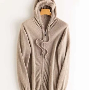 kashmir hoodie - Mjuk och lyxig beige hoodie i kashmir med dragkedja framtill och snörning i huvan. Tröjan har långa ärmar och ribbade muddar, perfekt för en chill och stilren look. Passar dig som gillar en enkel men exklusiv stil.