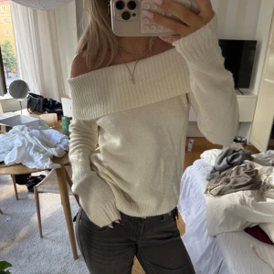 Offshoulder stickad tröja i cremevitt - Superfin offshoulder stickad tröja i cremevitt med bred ribbad kant upptill. Från Gina tricot i ull blandning. Mjuk och skön, perfekt till höst och vinter. Långärmad och sitter snyggt över axlarna för en chill men ändå stilren look.