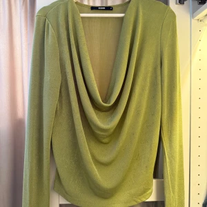 Grön topp från Bik Bok - Snygg ljusgrön topp från Bik Bok med lång ärm och draperad, djup urringning framtill. 