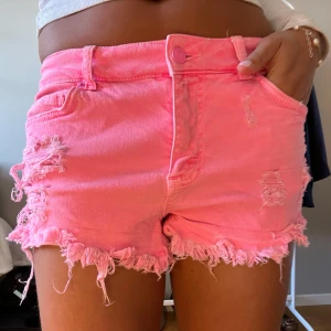 Rosa jeansshorts med fransig kant - Snygga rosa jeansshorts med fransig kant och slitna detaljer. 